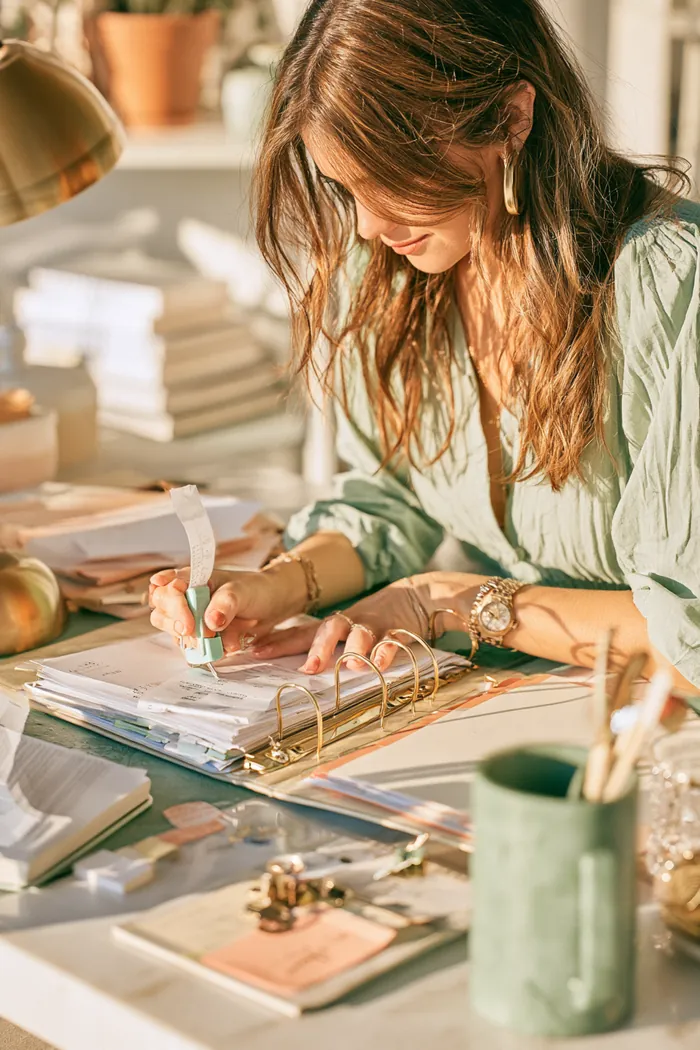 American woman organizing rate statements and receipts for a possible loan review in a binder